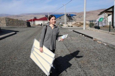 Elinde sınıf tahtasıyla kadınlar için kapı kapı geziyor