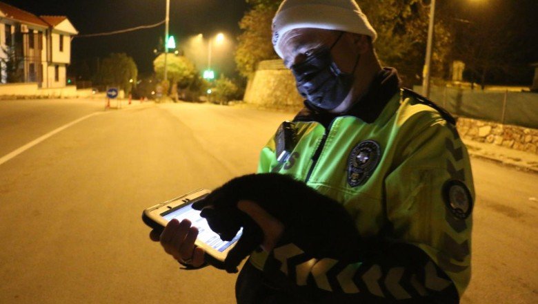 Trafik polisi araç altında kalmaktan kurtardığı kediyle uygulamaya devam etti