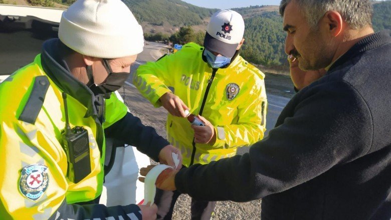 Polis devrilen tırdan çıkardığı sürücünün yaralanan elini sardı
